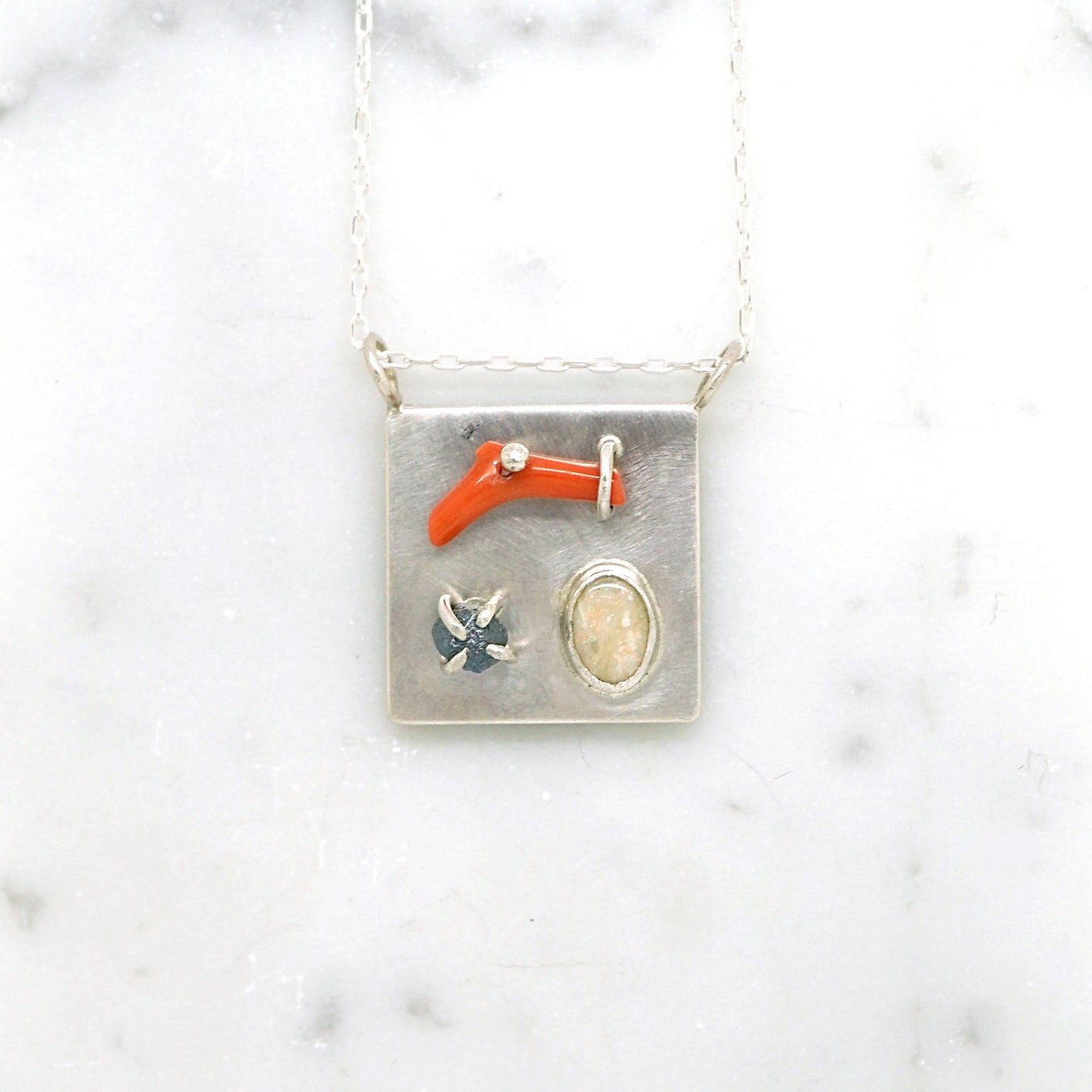 Art pendant necklace with coral, opal, and raw diamond