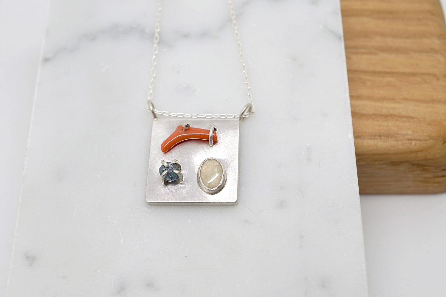 Art pendant necklace with coral, opal, and raw diamond