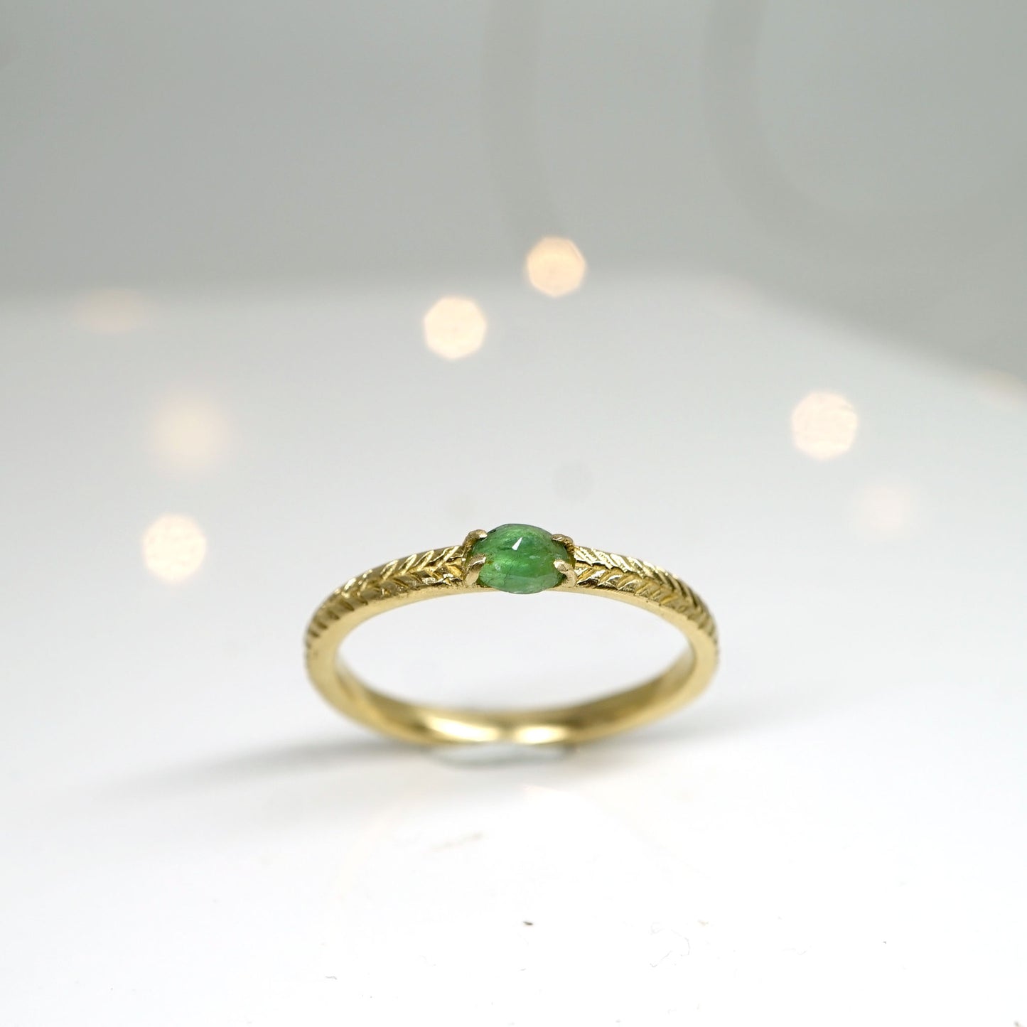 Emerald solitaire ring with details in 14k gold