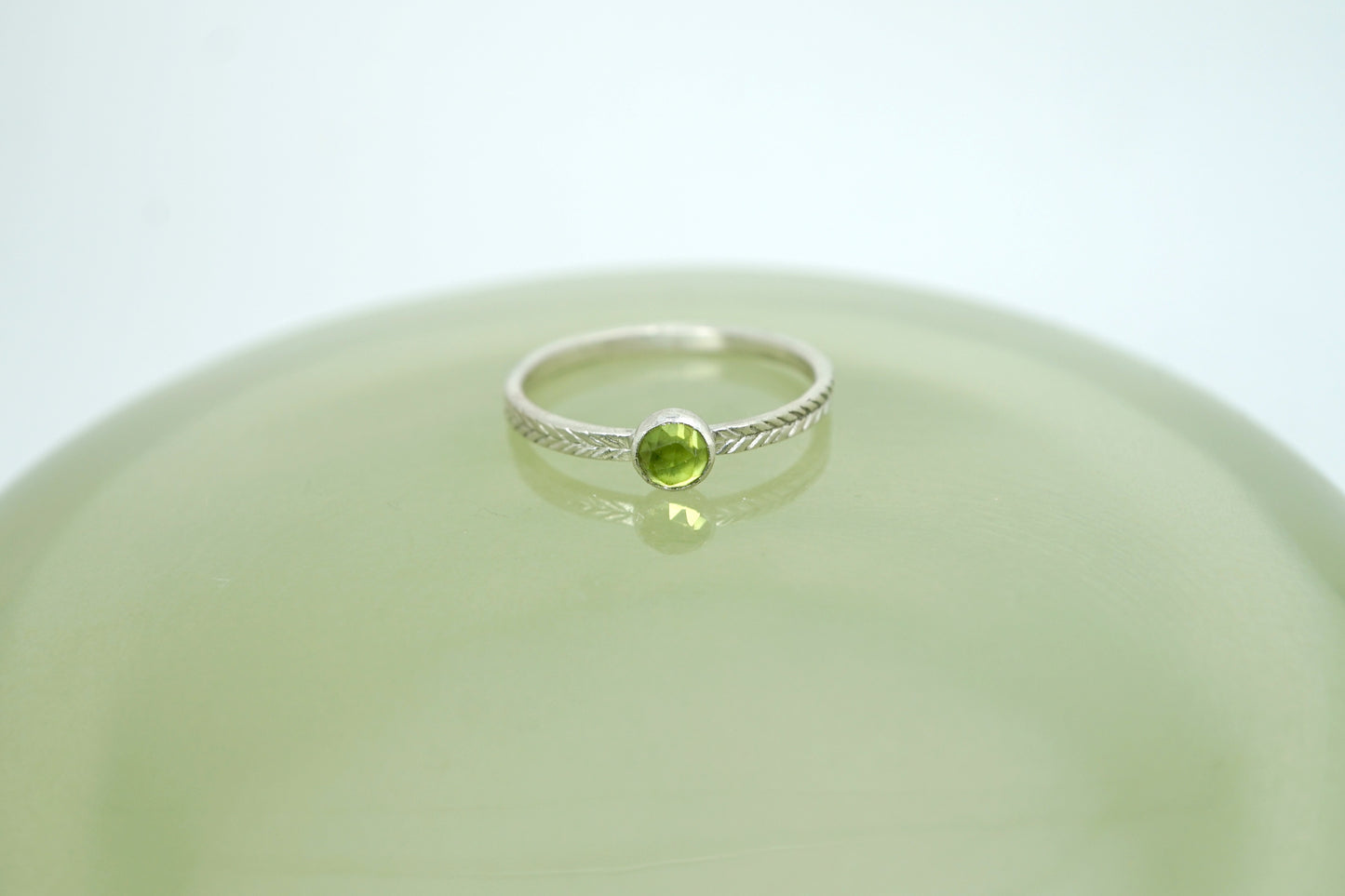 Peridot ring with hand-carved feather textures