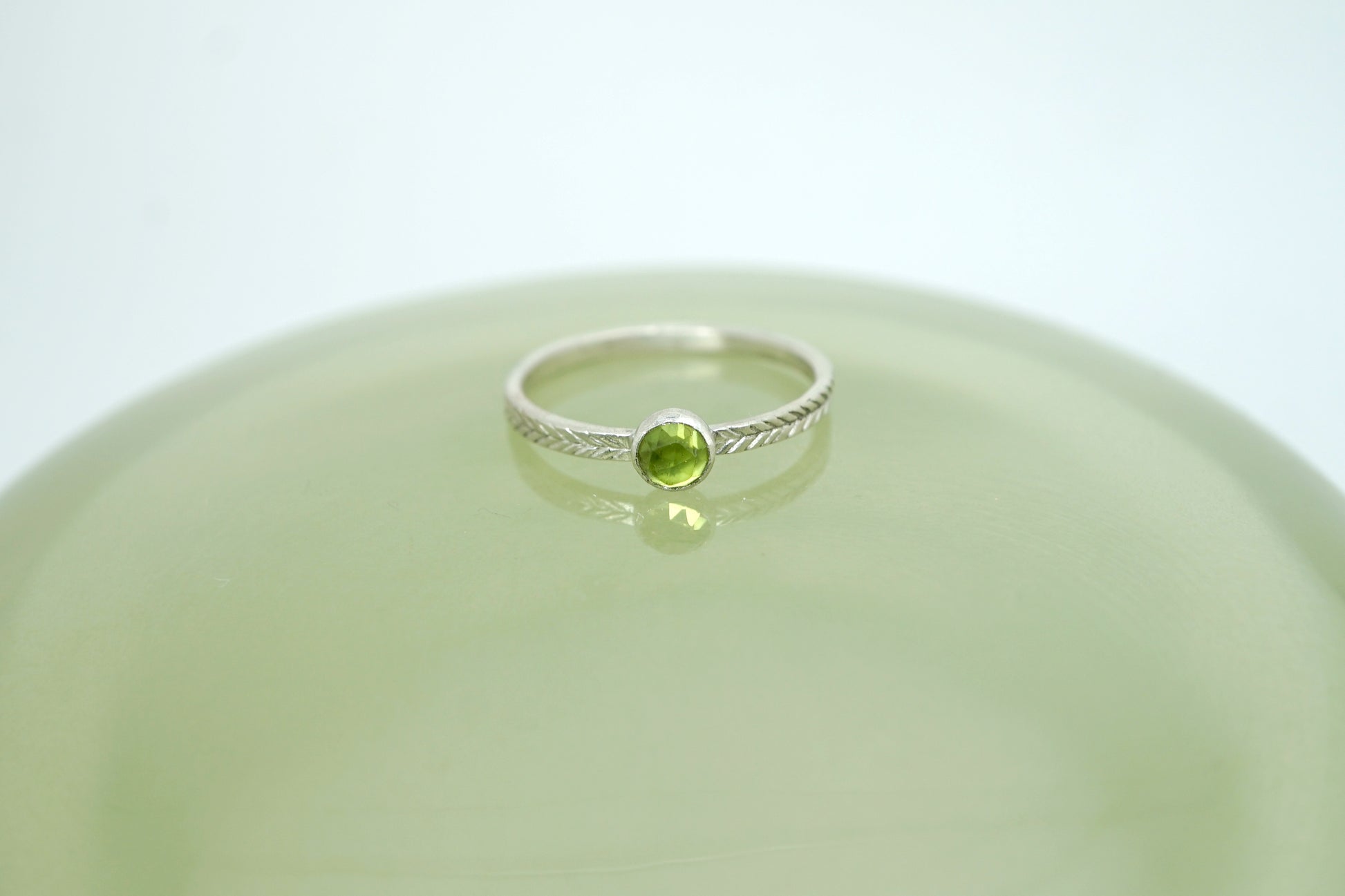 Peridot ring with hand-carved feather textures