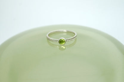 Peridot ring with hand-carved feather textures