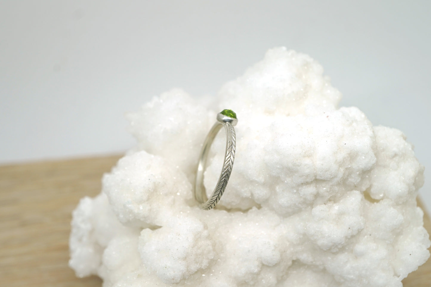 Peridot ring with hand-carved feather textures